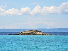 Kalogria beach, Small rocky island near in Sithonia, Chalkidiki, Greece, with a view on Kassandra peninsula.