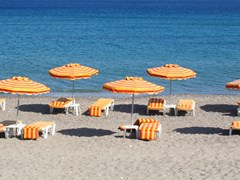 Греция. Остров Кос. Кефалос пляж. Оранжевые стулья и зонтики на пляже