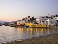 08_Sunset-on-the-sea-near-the-island-of-Mykonos-in-Greece-and-the-night-lights-of-restaurants-and-churches-on-the-beach-...