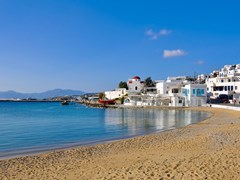14_The-famous-Tavern-on-the-sea-mirror-of-the-bay-of-the-island-of-Mykonos-with-a-red-boat-and-the-church